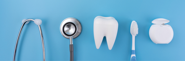 Medicare Part C: Dental and medical health concept featuring a stethoscope, white tooth model, toothbrush, and dental floss on a blue background.